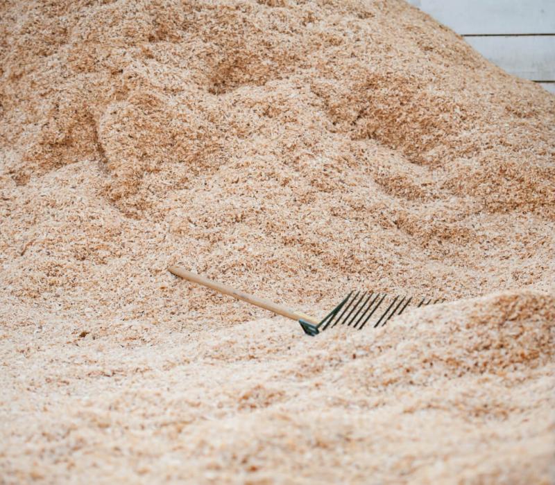 Piles of hay with a rake laying in it