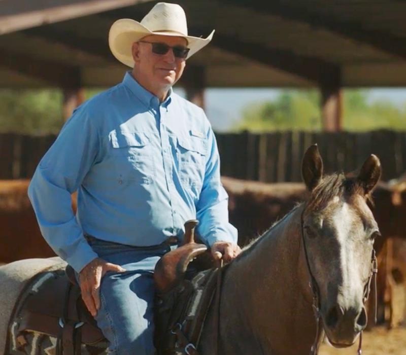 Veterinarian Al Dunning riding a horse in the sunlight